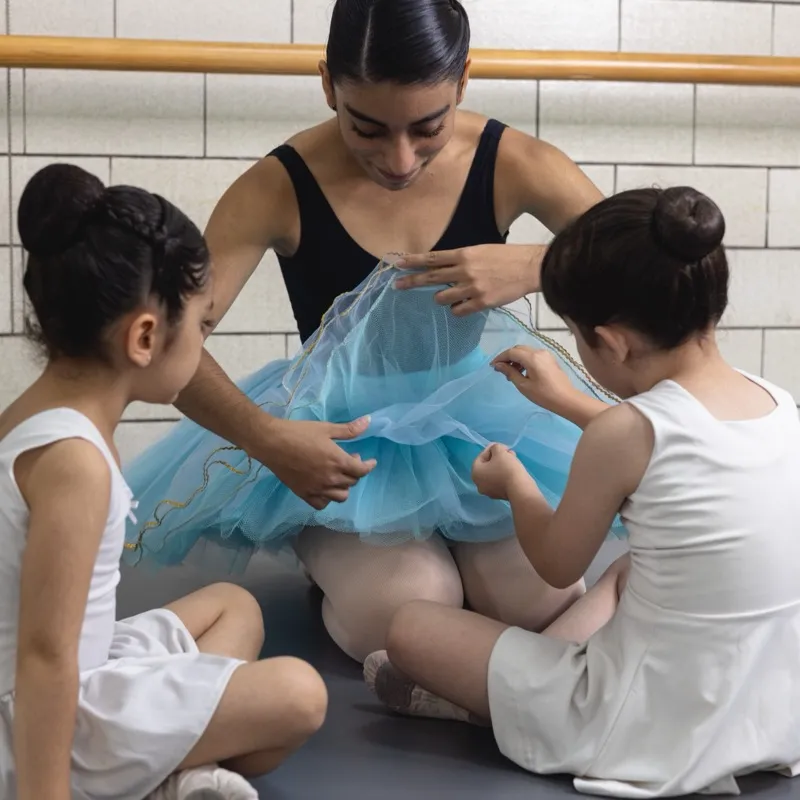 Maestra mostrando tutú a alumnas